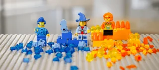 Lego Bauplatte mit drei Legofiguren und verschiedenen Legosteinen