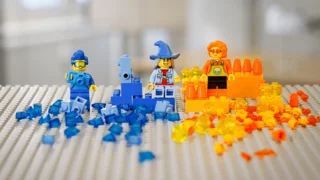 Lego Bauplatte mit drei Legofiguren und verschiedenen Legosteinen