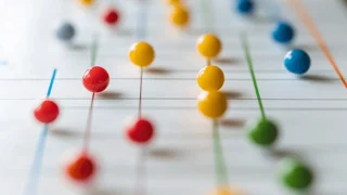 Farbige Stecknadeln auf einem Diagramm, die vernetzte Datenpunkte symbolisieren