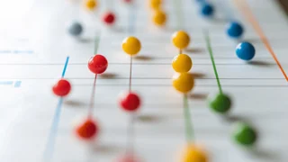 Farbige Stecknadeln auf einem Diagramm, die vernetzte Datenpunkte symbolisieren