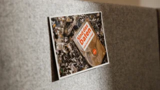Filzwand mit angepinnter Postkarte mit Schrott-Motiv und dem Text. Sind das daten oder kann das weg