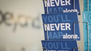 Kartenständer mit Postkarten mit Schriftzug: You`ll never map alone und forbeyond Schriftzug im Hintergrund