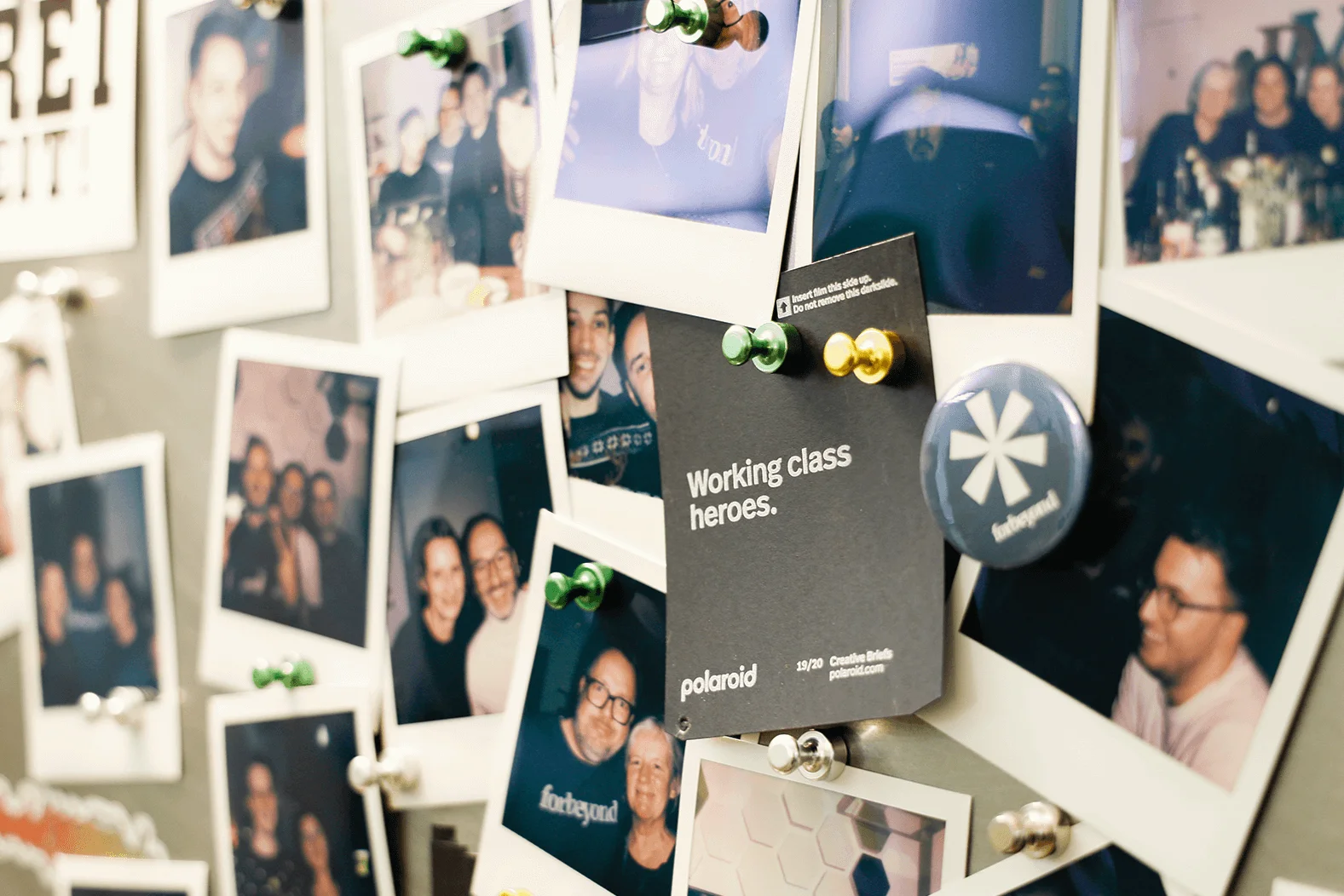 Pinnwand mit Polaroid-Fotos der Mitarbeiter von forbeyond, die Team- und Gemeinschaftsmomente festhalten